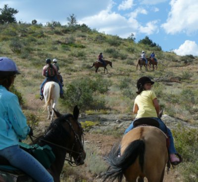 Kids riding horses in the mountains